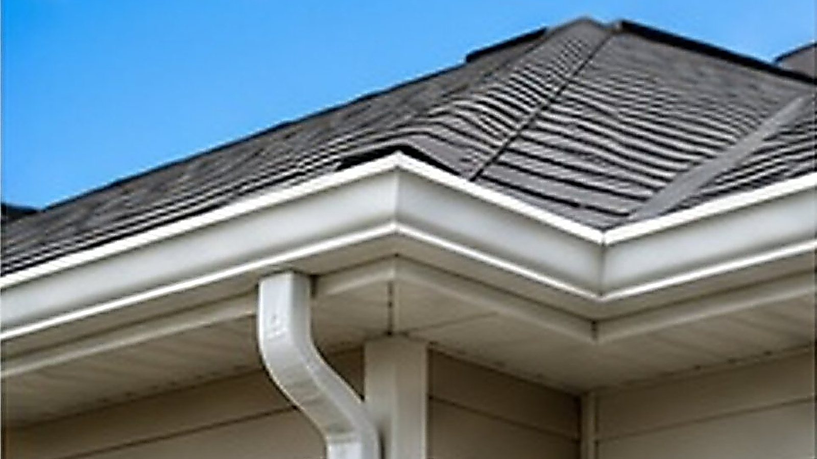 Clean roofline and gutters under a blue sky